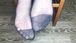Девушка в черных вкусных носочках показывает стопы и ноги